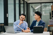 © laddawan - Male discussing new project with business colleague. Young man talking with young man in office.