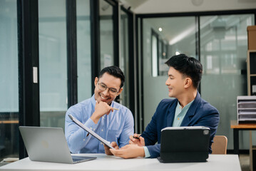 Wall Mural - Male discussing new project with business colleague. Young man talking with young man in office.