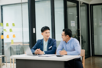 Wall Mural - Male discussing new project with business colleague. Young man talking with young man in office.