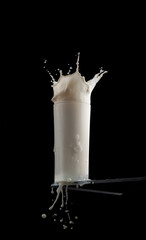 Wall Mural - fresh milk in a glass on table on black background,milk splash