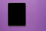 Fototapeta  - Top view of tablet on the violet pastel color background.