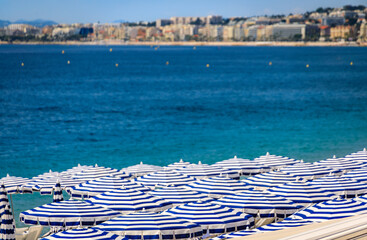 Sticker - Pebble beach along Promenade des Anglais with beach umbrellas and chairs with the turquoise water of the Mediterranean Sea in Nice, Cote d'Azur France