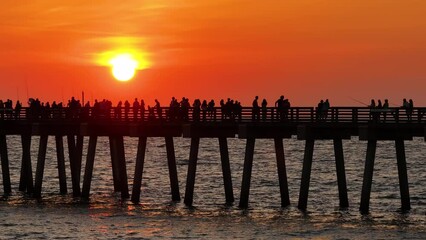 Canvas Print - Many fishermen tourists enjoying vacation time at sunset on Venice fishing pier. Seaside summer activities