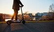 © baranq - Unrecognisable man riding electric scooter in city during sunset