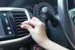 Close up woman hand is adjusting air conditioner in the car. Car cooling control button. hot air conditioner in car, heat and warm, checking air. over cooling or over heating in car.