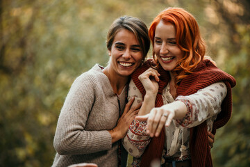 The joyous ambiance of a garden party, with a lesbian proposal with a diverse group of people relishing a shared meal amidst nature's beauty.