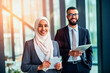 © the_lightwriter - muslim businesswoman with co-worker in an office