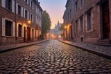 Fototapeta Uliczki - freshly swept cobblestone street at dawn