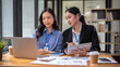 © bongkarn - Two beautiful and focused young Asian businesswomen are sharing their project ideas.
