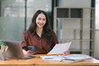 © kenchiro168 - Young Indian businesswoman working with a pile of documents at her office workplace, focusing on business finance and accounting concepts.