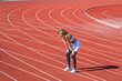 © Yevhen - Break, tired woman at stadium for a workout, training or breathing after cardio. Sports, race and an athlete runner, fitness, running or exercise on track. Tired girl on stadium. Tired sportswoman