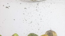 Sliced Kiwi Falling Into Water. Delicious Kiwi Fruit On White Background With Water Bubbles And Splashes. Concept Of Natural And Organic Food, Nutrition, Diet, Vitamins. Space For Ad