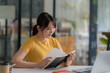 © amnaj - Young Asian Woman Studying with Laptop and Taking Notes for Online Learning