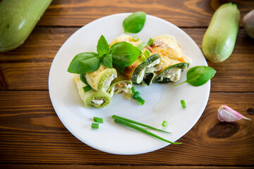 Wall Mural - cooked zucchini rolls with cheese filling inside, in a plate