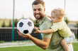 © Petro - Father with son playing football at the football field