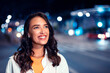 © Prostock-studio - Excited caucasian woman walking on urban city street at night, bokeh and neon city lights on background