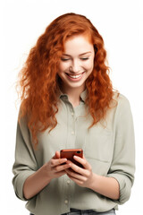 Wall Mural - Beautiful red-haired smiling woman uses a mobile phone on a white background