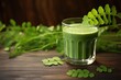 Moringa leaves extract in a glass on wooden background