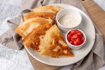 Golden and crispy chicken and cheese quesadilla with sides