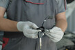 © Jevgenyij - An auto mechanic holds in his hands a new ignition lock and a set of ignition keys for a passenger car. Repair and maintenance of the car in the car service.