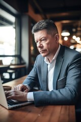 Sticker - shot of a businessman looking at information on his laptop in a coffee shop