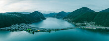 Panoramic Aerial View Of Melide, A Small Town Along The Lugano Lake With A Road Bridge Crossing The Lake At Sunset In Ticino, Switzerland.