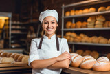 Fototapeta Sypialnia - Young female baker standing at workplace on baking manufacture.
