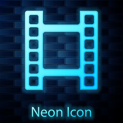 Sticker - Glowing neon Play Video icon isolated on brick wall background. Film strip sign. Vector