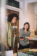 © Maskot - Saleswoman gesturing while sharing digital tablet in fashion boutique