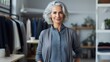 © piai - Senior fashion designer with grey hair standing in her office. Generative AI
