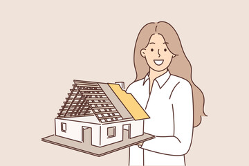 Woman architect holds model of house, demonstrating engineering solution for construction buildings