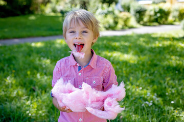 Sticker - Cute preschool child, eating pink sugar candy cotton in the park