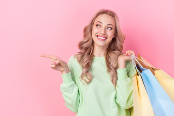 Photo of young promoter girl blonde curls wear green sweatshirt pointing finger mockup discount purchase isolated on pink color background