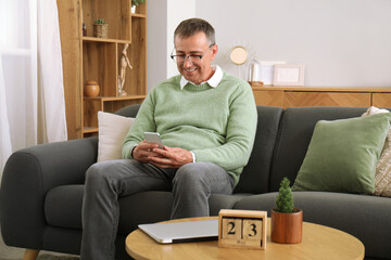 Poster - Mature man with mobile phone messaging at home