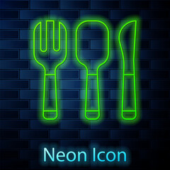 Poster - Glowing neon line Fork, spoon and knife icon isolated on brick wall background. Cooking utensil. Cutlery sign. Vector