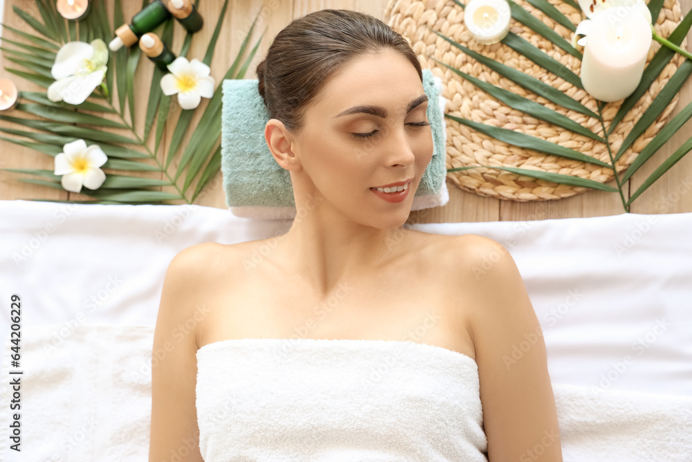 Young woman relaxing in spa salon, top view