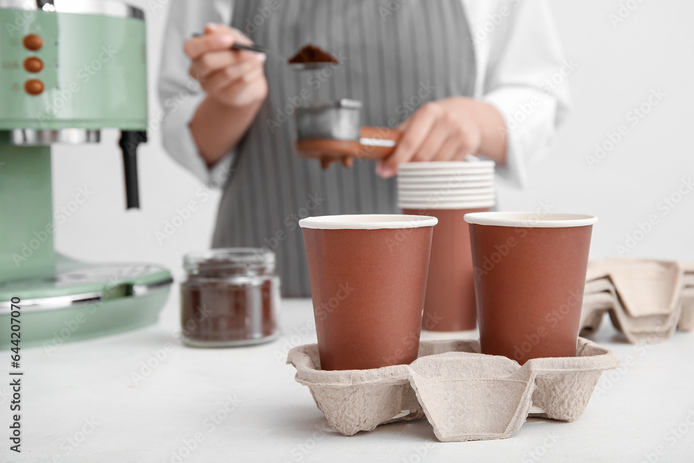 Holder with takeaway cups of tasty coffee on table