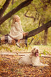 © Olga - Little girl with white hair with dogs in the park in autumn