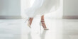 Bride feet walking with white heels. Closeup of woman legs in white bridal high heel shoes. 
