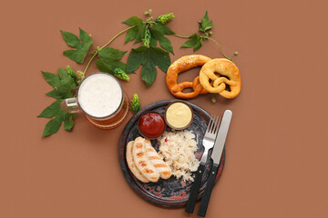 Plate with tasty Bavarian sausages, pretzels, sauerkraut, sauces and mug of beer on brown background. Oktoberfest celebration