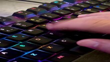 Close Up Of A Hand Pressing The Keys Of A Gaming Computer Keyboard, With Backlit Black Keys Changing Color,human Hand Tapping A Keyboard,  RGB Light, 4k, Vertical