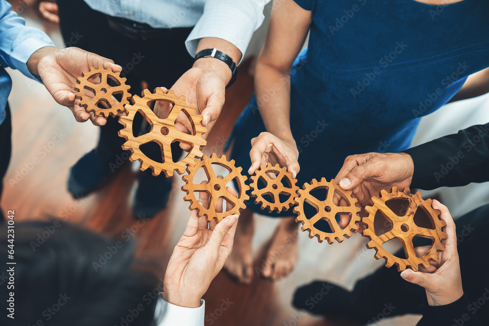 Foto de Stock Office worker holding cog wheel as unity and teamwork in ...