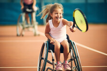 Happy Disabled Young Girl In A Wheelchair At Sport Playing Tennis