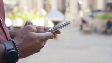Male hands using a smart phone out in the city