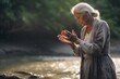 Intimate portrayal of a standing female aged 65 praying near a river