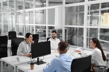 Canvas Print - Colleagues working together in open plan office