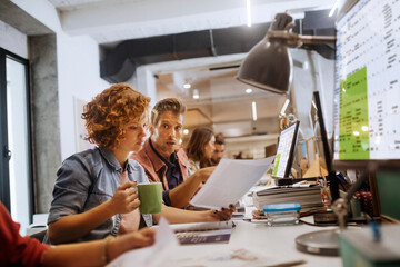 Wall Mural - Young and diverse group of people working together in the office of a startup company