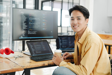 young programmer working on desktop pc in office of software company.