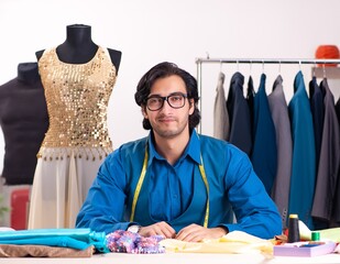 Wall Mural - Young male tailor working at workshop