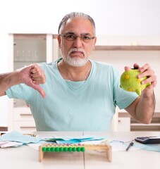 Wall Mural - White bearded old man in budget planning concept